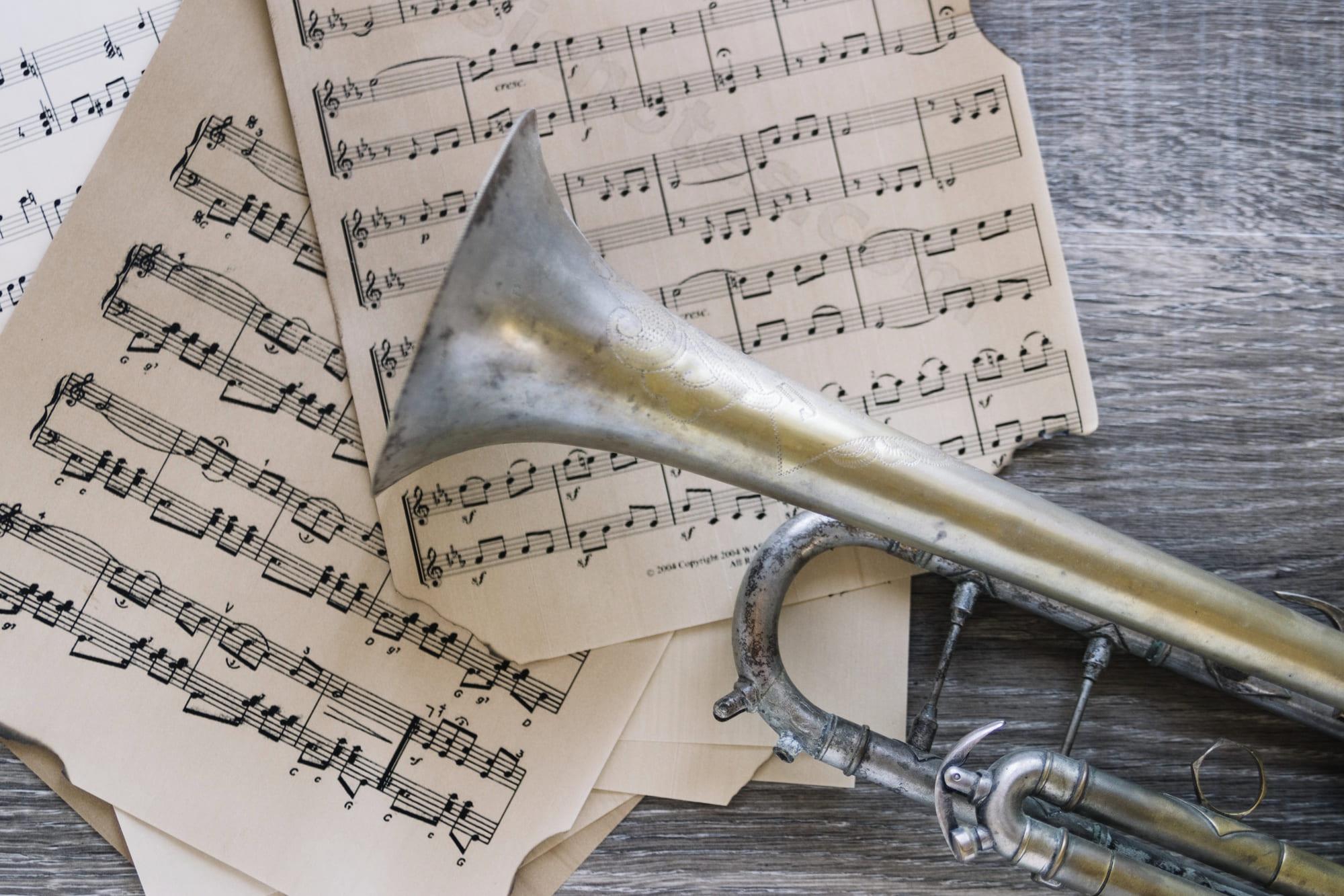 Notizbuch, Kaffeetasse und Trompete auf einem Tisch mit Notenblättern – stimmungsvolle Vorbereitung auf die Chorprobe im Klaukenhof