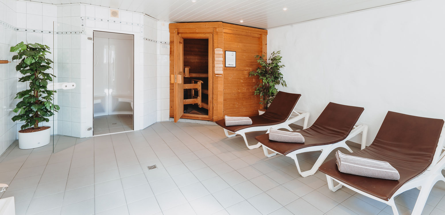 Moderner Saunabereich mit Holzliegen und stimmungsvoller Beleuchtung im Landhotel Klaukenhof