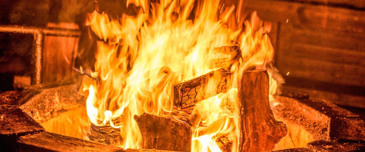 Gemütliche Feuerstelle vor der rustikalen Lustscheune im Landhotel Klaukenhof bei Abenddämmerung