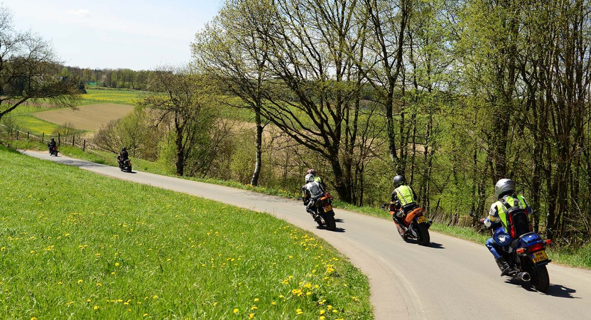 Kurvige Landstraße durch hügelige Landschaft im Sauerland, ideal für Motorradtouren